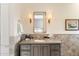 Bathroom with light gray cabinetry, tile backsplash, double sconces, and decorative accessories at 10244 E Hualapai Dr, Scottsdale, AZ 85255