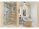 Bright bathroom featuring a glass shower with seat and a soaking tub with scenic backyard views at 10244 E Hualapai Dr, Scottsdale, AZ 85255