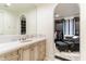 Bathroom showcasing a vanity with sink and seating area leading into a walk-in closet space at 10244 E Hualapai Dr, Scottsdale, AZ 85255