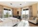 Bedroom featuring a bed, desk, seating area, and large windows overlooking the landscape at 10244 E Hualapai Dr, Scottsdale, AZ 85255