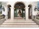 Grand entryway featuring stone steps, elegant columns, and a wrought-iron chandelier at 10244 E Hualapai Dr, Scottsdale, AZ 85255