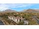 Panoramic view of a luxury home featuring a clay tile roof, mountain views, and desert landscaping at 10244 E Hualapai Dr, Scottsdale, AZ 85255