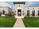 Elegant gray home featuring manicured landscaping, a brick pathway, and a grand entryway with decorative stone accents at 10244 E Hualapai Dr, Scottsdale, AZ 85255