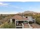 Scenic view of a home featuring a clay tile roof, a balcony, and stunning mountain views, creating a tranquil ambiance at 10244 E Hualapai Dr, Scottsdale, AZ 85255