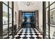 Foyer with black and white checkered floors, chandelier and doors leading to pool at 10244 E Hualapai Dr, Scottsdale, AZ 85255