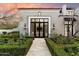 Stately front entrance with double doors, manicured hedges, and custom lighting at 10244 E Hualapai Dr, Scottsdale, AZ 85255