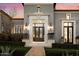 Elegant entrance showcasing a decorative doorway, manicured greenery, and classic lighting fixtures, offering a warm welcome at 10244 E Hualapai Dr, Scottsdale, AZ 85255