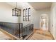 Open hallway with high ceilings, modern light fixture, black metal railing and view of an arched doorway at 10244 E Hualapai Dr, Scottsdale, AZ 85255