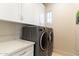 Laundry room with gray washer and dryer, white cabinets, and white countertops at 10244 E Hualapai Dr, Scottsdale, AZ 85255