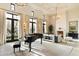 Elegant living room featuring high ceilings, large windows, fireplace, and a grand piano at 10244 E Hualapai Dr, Scottsdale, AZ 85255