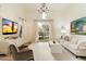 Bright living room with high ceilings, chandelier, and large window with backyard view at 10244 E Hualapai Dr, Scottsdale, AZ 85255