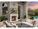 Relaxing outdoor living space with a fireplace, comfortable seating, and a view of the pool at 10244 E Hualapai Dr, Scottsdale, AZ 85255