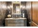 Charming powder room displaying patterned wallpaper, an antique vanity, and decorative sconces at 10244 E Hualapai Dr, Scottsdale, AZ 85255