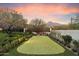 Backyard putting green featuring manicured landscaping, mountain views, and comfortable bench seating at 10244 E Hualapai Dr, Scottsdale, AZ 85255