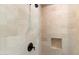 Tiled shower with rainfall shower head, niche, and bronze fixtures at 10244 E Hualapai Dr, Scottsdale, AZ 85255