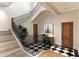 Grand staircase showcasing a black iron railing, natural wood steps, and black-and-white checkered landing at 10244 E Hualapai Dr, Scottsdale, AZ 85255