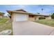 Inviting home showcasing a well-maintained lawn, attached garage, and charming front entryway at 10816 W Hatcher Rd, Sun City, AZ 85351