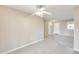 Open living room with tile and carpet flooring, ceiling fan, and neutral paint at 10816 W Hatcher Rd, Sun City, AZ 85351