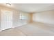 Cozy living room featuring plush carpet, a large window, and a welcoming front door at 10816 W Hatcher Rd, Sun City, AZ 85351