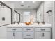 Bathroom featuring double sinks, modern fixtures, sleek vanity, and well-lit mirror creates a functional space at 10823 W Polk St, Avondale, AZ 85323