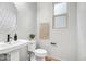 Modern half bathroom with a pedestal sink, decorative mirror, and stylish wall decor for added charm at 10823 W Polk St, Avondale, AZ 85323