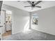 Bright bedroom with a ceiling fan, carpet, and ensuite bathroom with a view of the neighborhood at 10823 W Polk St, Avondale, AZ 85323