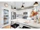 Bright, white kitchen with stainless steel appliances and a large island featuring stylish pendant lighting at 10823 W Polk St, Avondale, AZ 85323