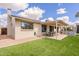 A backyard featuring a covered patio, built in grill, green grass, a table, and a view of the home at 10903 E Sahuaro Dr, Scottsdale, AZ 85259