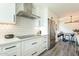 Bright kitchen with stainless steel appliances, white cabinetry, and an open layout leading to the dining area at 10903 E Sahuaro Dr, Scottsdale, AZ 85259