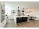 Bright kitchen with stainless steel appliances, island with seating, and modern white cabinets at 10903 E Sahuaro Dr, Scottsdale, AZ 85259