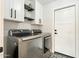 Modern laundry room with sleek, front-loading washer and dryer, stylish black and white tile floor at 10903 E Sahuaro Dr, Scottsdale, AZ 85259