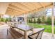 Covered outdoor dining area with a wooden table, chairs, and bench, perfect for entertaining at 10903 E Sahuaro Dr, Scottsdale, AZ 85259