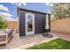 A backyard featuring a gray sofa and a view of the black storage shed and umbrella at 10903 E Sahuaro Dr, Scottsdale, AZ 85259