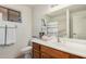 Well-lit bathroom with a single sink, window, and storage cabinets at 11046 E Naranja Ave, Mesa, AZ 85209