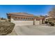 Attractive home displaying a three-car garage, tiled roof, and low-maintenance desert landscaping at 11046 E Naranja Ave, Mesa, AZ 85209