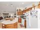 Bright kitchen featuring oak cabinets, center island and modern white appliances at 11046 E Naranja Ave, Mesa, AZ 85209