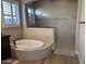 Bright bathroom featuring a tub with black hardware and a glass-enclosed shower at 11612 W Candelilla Way, Peoria, AZ 85383