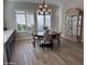 Dining room with decorative chandelier, modern furniture, display cabinet, and windows with plantation shutters at 11612 W Candelilla Way, Peoria, AZ 85383