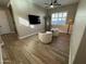 Stylish living room featuring wood-look tile flooring, a ceiling fan, and cozy seating near a window with white shutters at 11612 W Candelilla Way, Peoria, AZ 85383