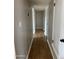 Hallway with wood floors, neutral walls, and doors leading to various rooms at 1172 E Delano Dr, Casa Grande, AZ 85122