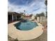 Inviting backyard pool with waterfall feature, stone accents, palm trees, and covered patio at 1172 E Delano Dr, Casa Grande, AZ 85122