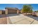 Charming single-story home with a two-car garage, concrete driveway and desert landscaping at 14787 W Aster Dr, Surprise, AZ 85379