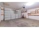 Spacious garage with overhead door, storage shelves and room for parking and projects at 14787 W Aster Dr, Surprise, AZ 85379