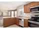 Kitchen with stainless appliances and wood cabinets and a view to the living spaces at 14787 W Aster Dr, Surprise, AZ 85379