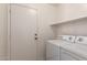 Functional laundry room featuring a washer, dryer, and convenient shelf space at 14787 W Aster Dr, Surprise, AZ 85379