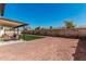 Red gravel backyard with small square of artificial turf and a covered patio with furniture at 15619 N 30Th Ave, Phoenix, AZ 85053