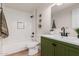 Stylish bathroom featuring a subway tile shower, green vanity, and sleek black fixtures at 15619 N 30Th Ave, Phoenix, AZ 85053