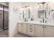 Bright bathroom featuring dual sinks, sleek black hardware, and a modern glass-enclosed shower at 15619 N 30Th Ave, Phoenix, AZ 85053