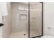 Modern shower with decorative tile inset, a glass door, and hexagonal tile flooring at 15619 N 30Th Ave, Phoenix, AZ 85053