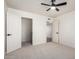 Bright, neutral bedroom with a ceiling fan, open closet, and adjoining doorway at 15619 N 30Th Ave, Phoenix, AZ 85053